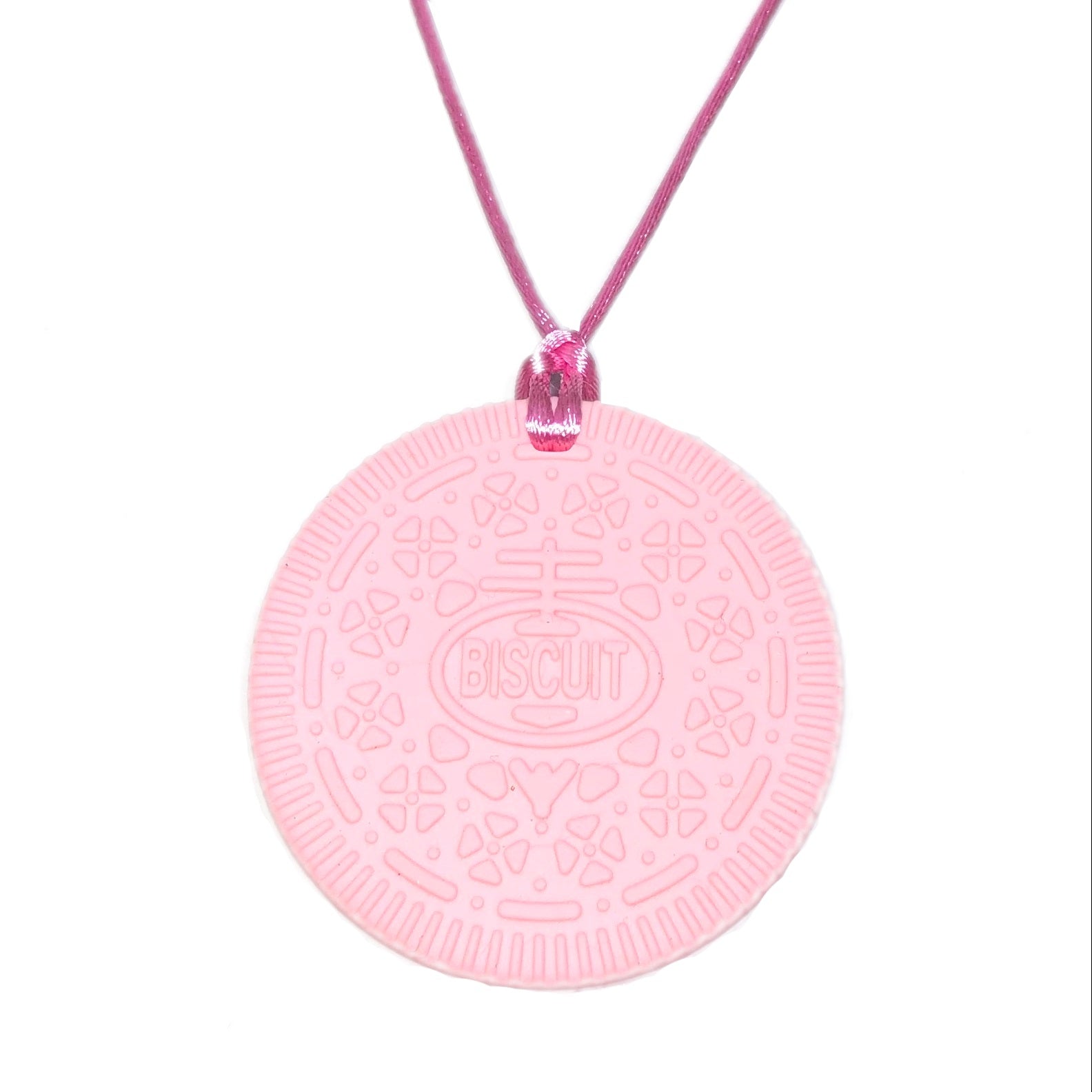 A pink Oreo-shaped pendant necklace on a matching pink cord, featuring an embossed biscuit pattern and the word 'BISCUIT' in the center, set against a plain white background.