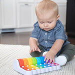 Child playing with a colorful toy on a carpeted floor.