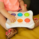 Child playing with a colorful educational toy on a yellow couch.