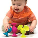 Child playing with colorful silicone suction cups on a white background