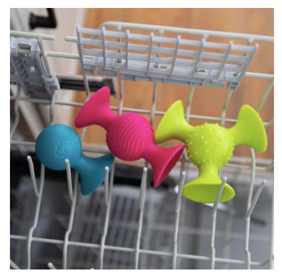 Colorful shapes in a dishwasher rack .