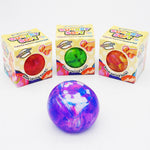 Three colorful squeeze balls in front of their retail boxes on a white background. 