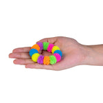 Colorful fuzzy ball bracelet held in a hand on a white background