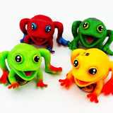Four frog toys in red, green, yellow, and orange-red, arranged on a plain white background.