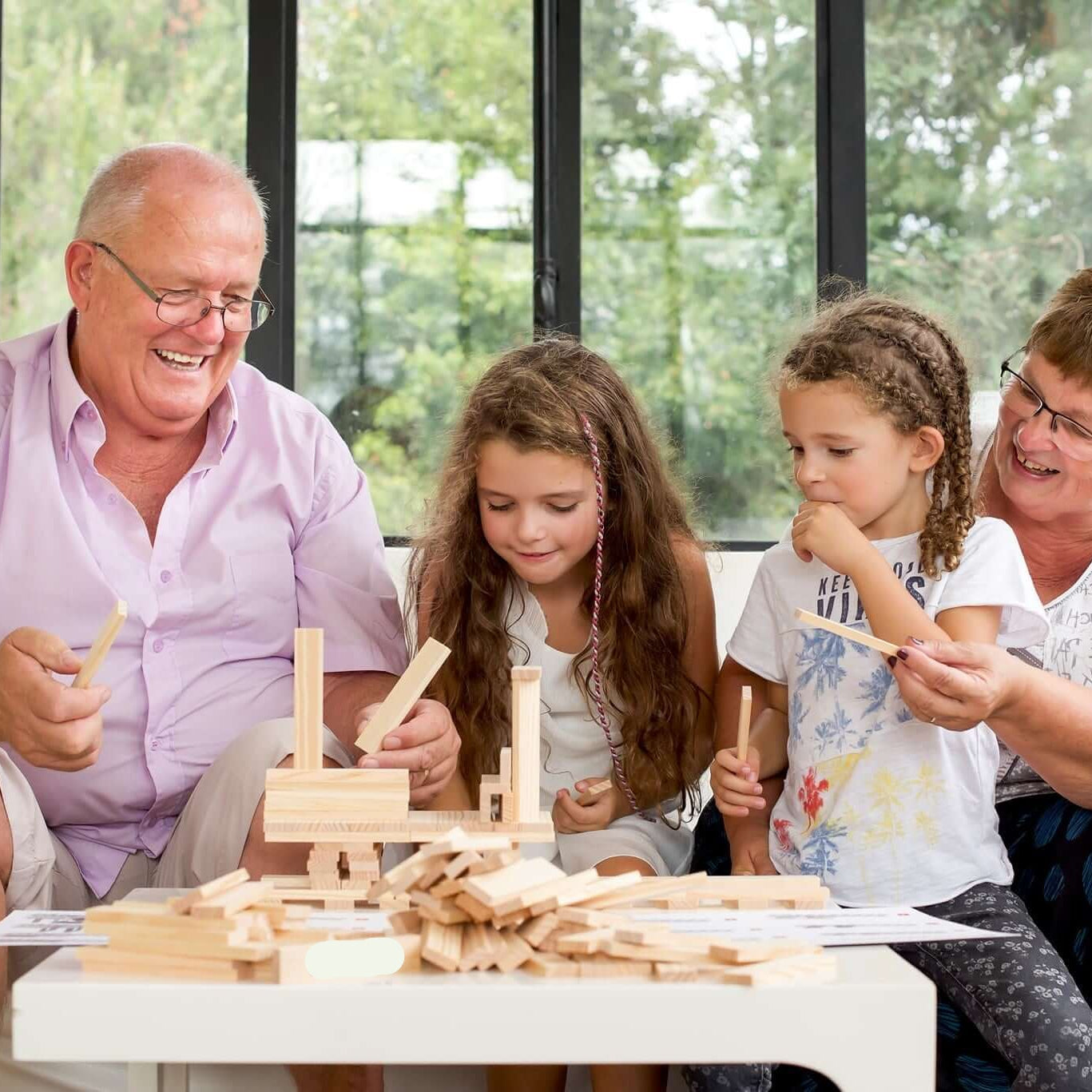 Family playing with wooden toys in a bright room